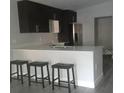 Modern kitchen featuring sleek cabinets, stainless steel appliances, and bar-style seating at 1605 N Orange St, Mount Dora, FL 32757