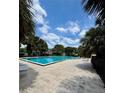 Large community pool surrounded by palm trees, ideal for swimming and recreation at 1844 Townhall Ln # 1844, Orlando, FL 32807