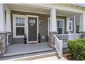 Charming front porch with stone accents, columns, and decorative plants framing the inviting entryway at 2057 Celebration Blvd, Celebration, FL 34747