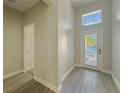 Bright entryway with wood-look tile flooring and transom window above the front door at 2164 Crosston Cir, Orlando, FL 32824