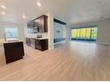 Open kitchen with dark cabinets, stainless appliances, and island flowing into the living area at 2164 Crosston Cir, Orlando, FL 32824