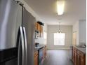 Kitchen with stainless appliances and wooden cabinetry, flowing into the dining area at 257 Lancaster Dr, Davenport, FL 33897