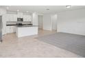 Open-concept kitchen with white cabinets, a center island, and tile flooring at 3214 Viceroy Ct, Kissimmee, FL 34759