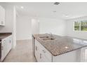 Modern kitchen featuring a granite island with a stainless steel sink and a view of the outdoors at 3214 Viceroy Ct, Kissimmee, FL 34759