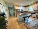 Bright kitchen with an island, stainless steel appliances, white cabinets, and tile flooring near the doorway at 3333 Sagebrush St, Harmony, FL 34773