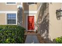 Close-up of the home's red front door with manicured shrubs and a welcoming entrance at 3391 Cortland Dr, Davenport, FL 33837