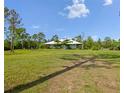 Expansive front lawn with a single-story home in the background, featuring a light-blue facade and covered porch at 4730 Cypress Creek Ranch Rd, St Cloud, FL 34771