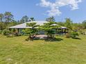 A quaint light-blue, single-story home with a covered porch and lush landscaping, surrounded by a spacious front lawn at 4730 Cypress Creek Ranch Rd, St Cloud, FL 34771