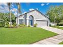 Beautiful single-Gathering home showcasing a lush green lawn and vibrant landscaping under a sunny sky at 501 Dunoon St, Ocoee, FL 34761
