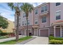 Three-story townhome featuring individual garages, private entrances and lush tropical landscaping with palm trees at 5038 Tideview Cir # 21, Orlando, FL 32819