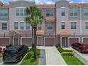 Three-story townhome featuring individual garages, private entrances and lush tropical landscaping with palm trees at 5038 Tideview Cir # 21, Orlando, FL 32819