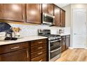 Modern kitchen with white counters, stainless steel appliances, wood look flooring and dark cabinets at 5139 Kinsley Dr, Lake Wales, FL 33859