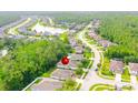 Aerial view of a residential area with lush green trees, a lake and well-maintained single-Gathering houses at 56 Levee Ln, Ormond Beach, FL 32174