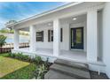 Inviting covered front porch with decorative columns and beautiful entry door, enhancing the home's curb appeal at 6479 Apple St, St Cloud, FL 34771