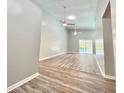 Bright living room with vaulted ceilings, modern ceiling fans, and beautiful wood-look flooring with pool view at 713 Wood Ln, Kissimmee, FL 34759