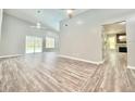 Spacious living room with views of pool, modern ceiling fans, and fireplace next to modern kitchen at 713 Wood Ln, Kissimmee, FL 34759