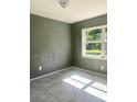 Cozy bedroom with tile flooring and natural light streaming through the window at 721 S Clyde S Ave, Kissimmee, FL 34741