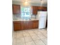 Functional kitchen equipped with wood cabinets, granite countertops, and modern appliances at 721 S Clyde S Ave, Kissimmee, FL 34741