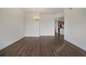 Open living area with gleaming wood floors and a view into the kitchen at 7468 Excitement Dr # 101, Reunion, FL 34747