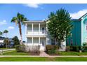 Inviting two-story home features a double balcony and a lush, flowering tree in the front yard at 7740 Linkside Loop, Reunion, FL 34747