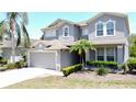 Charming two-story home with gray stucco, neutral trim, attached two-car garage, and well manicured landscaping at 805 Suffolk Pl, Davenport, FL 33896
