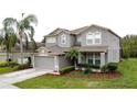 Attractive two-story home boasting a well-maintained lawn, a 2-car garage, and lush landscaping at 805 Suffolk Pl, Davenport, FL 33896