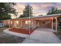 Inviting single-story home with front yard, carport, decorative lighting, and tidy landscaping, perfect for curb appeal at 807 E Airport Blvd, Sanford, FL 32773
