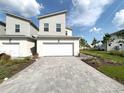 Modern two-story home with a two car garage, neutral paint, paved driveway, and minimal landscaping at 921 Spring Palms Loop, Orlando, FL 32828
