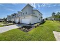 Contemporary townhome showcases a paved driveway, lawn, and minimalist landscaping in a modern style at 921 Spring Palms Loop, Orlando, FL 32828