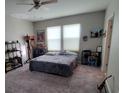 Spacious bedroom with neutral walls, carpet flooring, two windows, and ceiling fan at 12372 Stone Bark Trl, Orlando, FL 32824