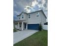 Two-story home featuring a two-car garage, a charming covered front porch, and well-maintained landscaping at 12372 Stone Bark Trl, Orlando, FL 32824