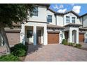Charming townhome showing landscaped front, private garage, and brick driveway at 1312 Royal St George Blvd, Davenport, FL 33896