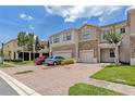 Charming townhome featuring a brick driveway, two-car garage, and stone facade at 1628 Portofino Meadows Blvd, Orlando, FL 32824