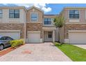 Attractive townhome showcasing a brick driveway, front yard, and two-car garage at 1628 Portofino Meadows Blvd, Orlando, FL 32824