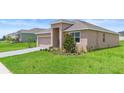 Charming single-story home featuring a brick driveway, lush lawn and welcoming covered entrance at 172 Roseville Dr, Haines City, FL 33844