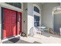 Covered porch with seating, a vibrant red door, and decorative touches at 1760 Boat Launch Rd, Kissimmee, FL 34746