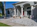 Home's front porch with stone landscaping, decorative pillars, and a cozy seating area at 1760 Boat Launch Rd, Kissimmee, FL 34746