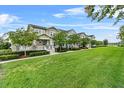 A row of houses faces a manicured green, each with a charming porch and landscaping at 1801 Coastal Ct, Celebration, FL 34747