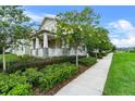 An attractive two-story home with stone accents and lovely landscaping along a sidewalk at 1801 Coastal Ct, Celebration, FL 34747