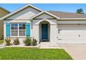 Close up of the exterior with turquoise shutters and an arched entryway at 2416 White Poppy Dr, Kissimmee, FL 34747