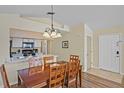 Inviting dining room featuring a wooden table set, complemented by a charming light fixture and open view to the kitchen at 3151 Britannia Blvd # C, Kissimmee, FL 34747