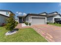 Attractive single-Gathering home with a well-maintained lawn and a brick driveway leading to a two-car garage at 3442 Monaco Ln, Davenport, FL 33897