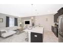 Bright open-concept living room with modern white furniture, sleek kitchen island, and tile flooring creates a stylish space at 4903 Windermere Ave, Kissimmee, FL 34746