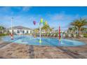 Community splash pad with colorful water features and nearby lounge chairs and palm trees at 4903 Windermere Ave, Kissimmee, FL 34746