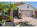 This charming home features a stone facade, a brick paver walkway and driveway, and beautiful tropical landscaping at 582 San Joaquin Rd, Kissimmee, FL 34759