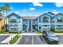Exterior shot of condo buildings with beautiful windows, a parking area, and well-maintained landscaping at 8716 Rain Forest Pl # D, Kissimmee, FL 34747