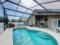 A screened-in pool area with an in-ground pool, patio furniture, and ample space for outdoor entertaining at 1364 Rebecca Dr, Haines City, FL 33844