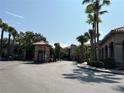The driveway is flanked by tropical palm trees and leads to a gated community of tile-roofed buildings at 1375 Tuscana Ln # 1405, Davenport, FL 33896