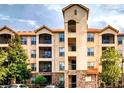 Exterior of the multi-story condominium building showing private balconies and manicured grounds at 1375 Tuscana Ln # 1405, Davenport, FL 33896