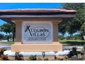 Audubon Villas at Hunter's Creek sign surrounded by well-maintained landscaping at 13838 Fairway Island Dr # 1418, Orlando, FL 32837